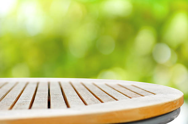 Round wood table top on bokeh green background