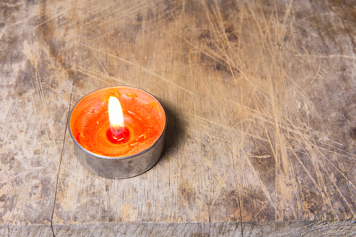 Orange candle on wooden table