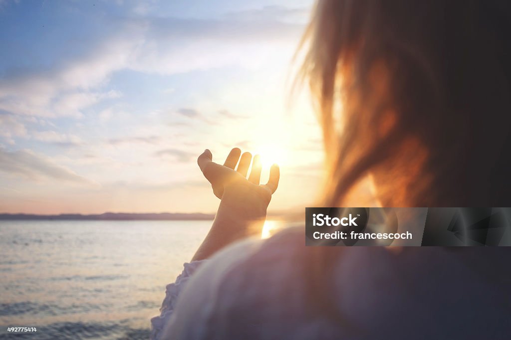 woman try to grab the sun Hope - Concept Stock Photo