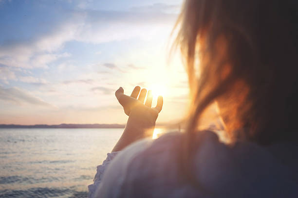 woman try to grab the sun stock photo