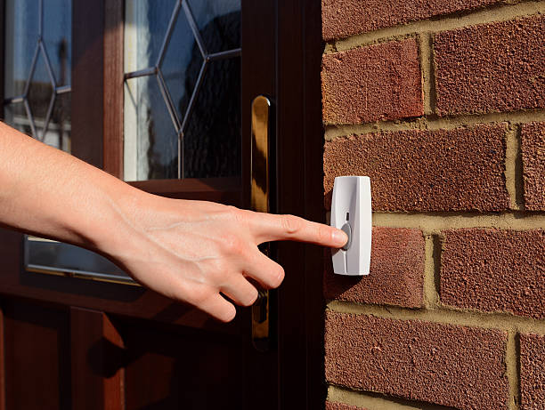 istock Woman extends her hand to ring doorbell 492775784