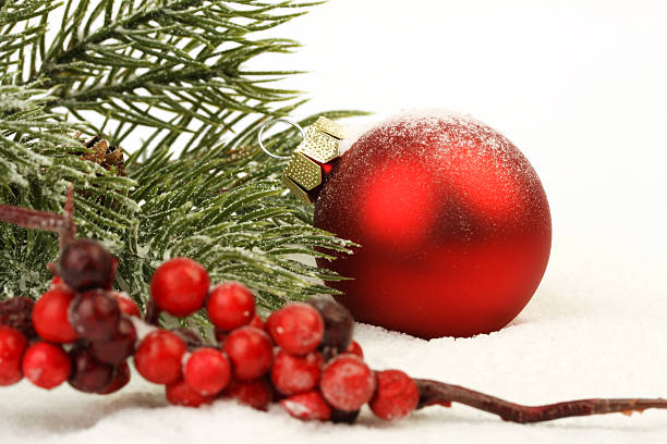 istock Red matt christmas ball on snow and red rowanberries 492775942