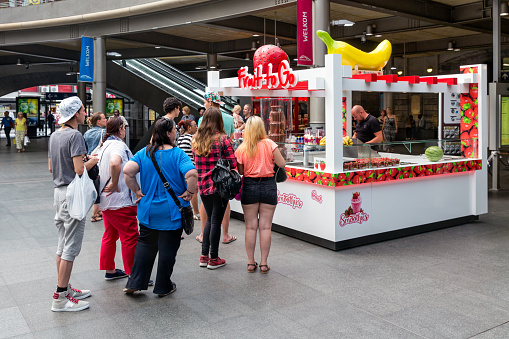Antwerp, Belgium - August 11, 2015:  People in waiting queue for a sweets kiosk at the Antwerp Central Station