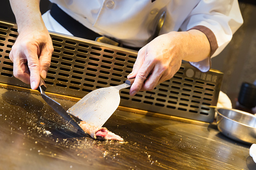 a japanese chef is cooking teppanyaki on a plate