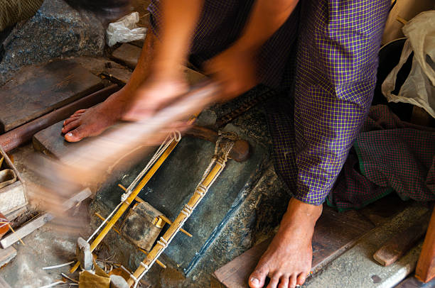 istock Young craftsman punching gold with a hammer 492785850