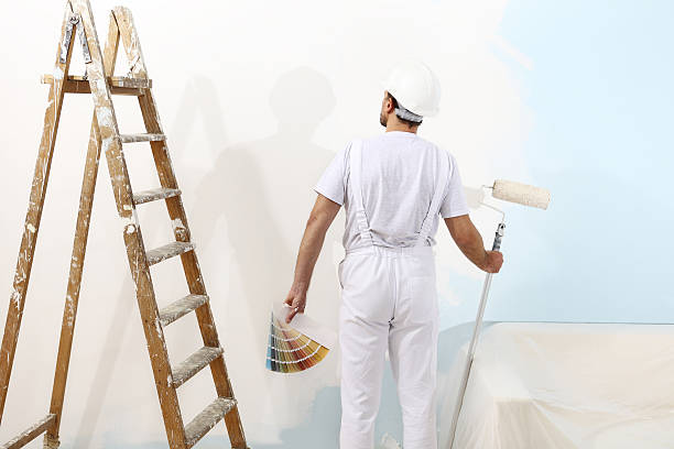 painter man with a paint roller and color samples painter man at work with a paint roller and color samples, wall painting concept house painter ladder paint men stock pictures, royalty-free photos & images