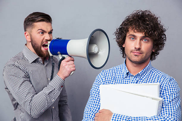 istock Businessman yelling via megaphone to another man 492787378