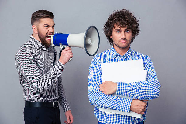 istock Businessman screaming via megaphone to another man 492787434