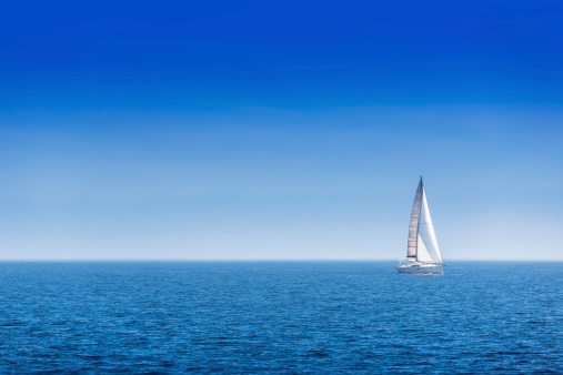 Sailing ship yachts with white sails, deep blue sky