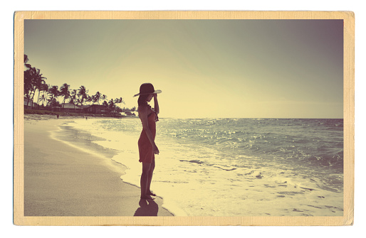 A Retro 40s-50s style antique postcard with a young woman on a tropical beach.