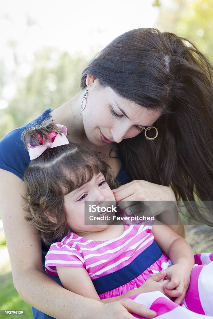 Loving Mother Consoles Crying Baby Daughter Mixed Race Loving Mother Consoles Her Crying Baby Daughter in Park. Adult Stock Photo