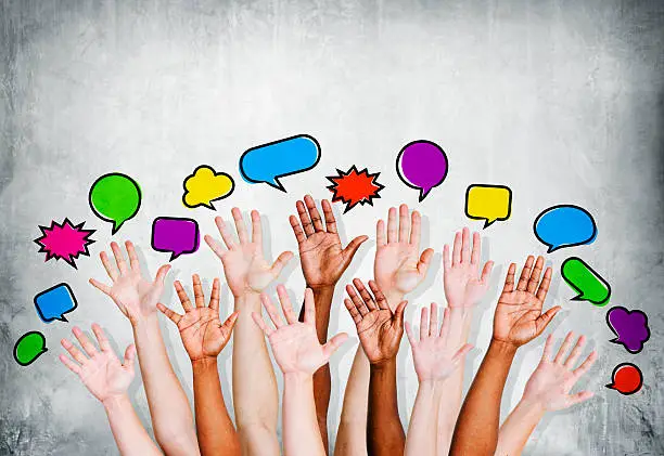 Photo of Multiethnic People's Hands Raised with Speech Bubble