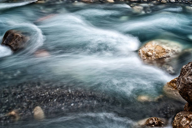 riverbed with blurred water sideview stock photo