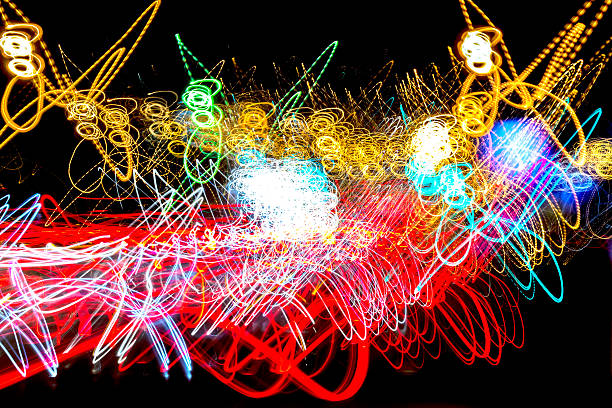 Light Trails Lightpainting Abstract Red Yellow Blue and Green Abstract  of Neon Sodium lights on a black background - strong lights combined with circular flashing orange ovals create a rich texture of bright lighting resembling pop art lightpainting stock pictures, royalty-free photos & images