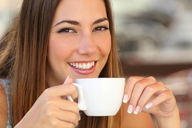 istock Woman tasting a coffee from a cup in restaurant terrace 492811642