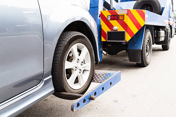 Tow truck towing a broken down Vehicle on the street Tow truck towing a broken down car on the street. car hauling stock pictures, royalty-free photos & images