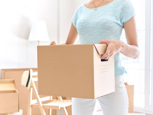 istock Woman carrying cardboard box 492812270