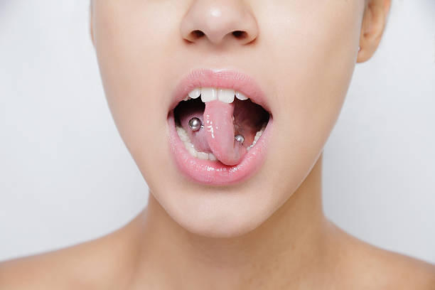 Beautiful woman sticking out her tongue and showing young piercing Beautiful woman sticking out her tongue and showing her young piercing Pierced stock pictures, royalty-free photos & images