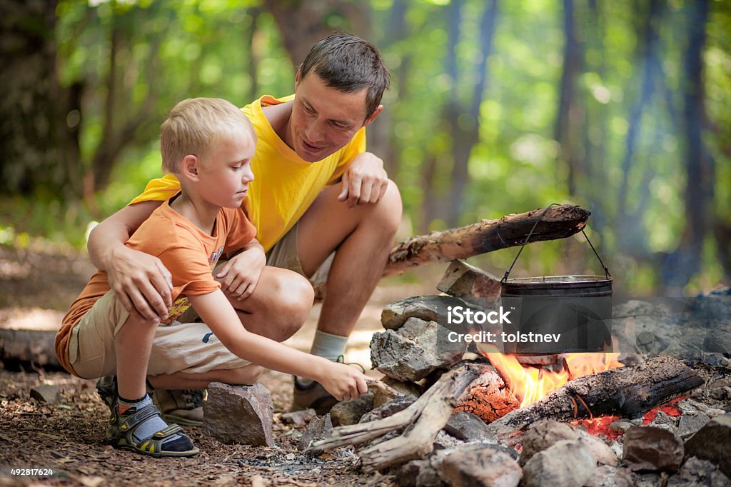 Father with son at camping Father with son at camping near campfire 2015 Stock Photo