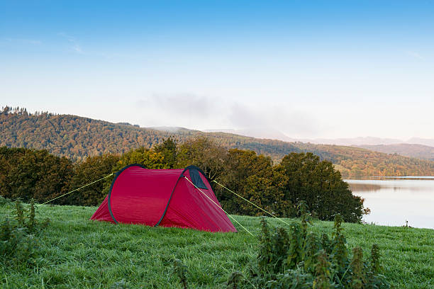 istock Red Tent on a hill overlooking a lake 492817716