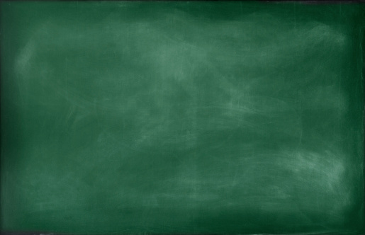 Close up of a green empty school chalkboard with chalk traces and smudges. Space for copy.
