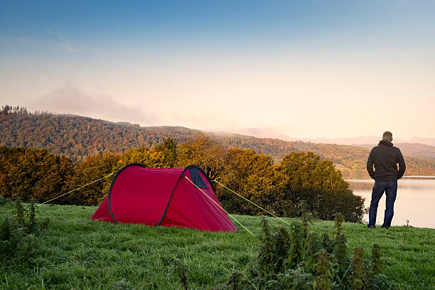istock Man stood next to a red tent on a hill 492839788