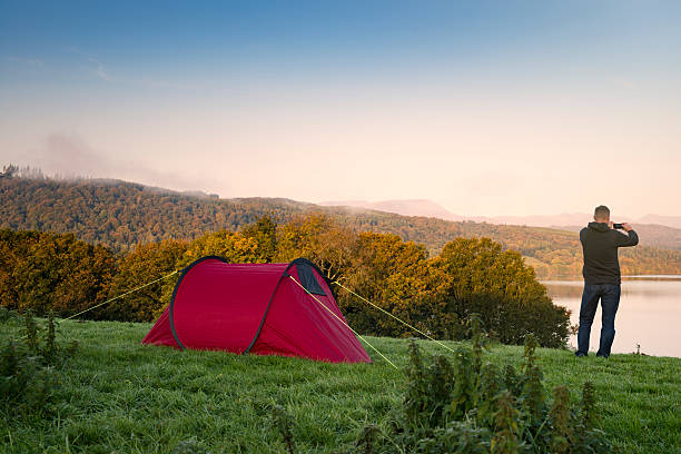 istock Man stood next to a red tent on a hill 492839994