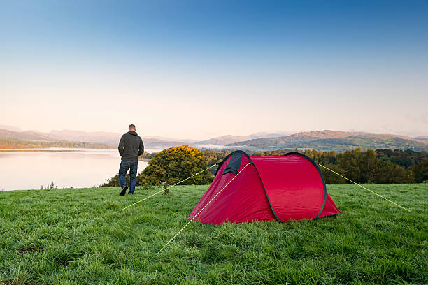 istock Man stood next to a red tent on a hill 492840158