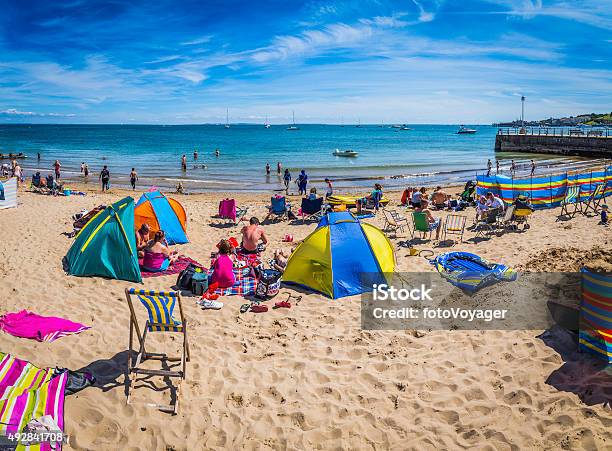 Crowds Sunbathing On Sandy Ocean Beach With Colourful Tents England Stock Photo - Download Image Now