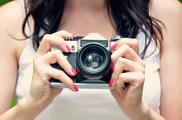 istock old retro photo camera in girl hands 492844284