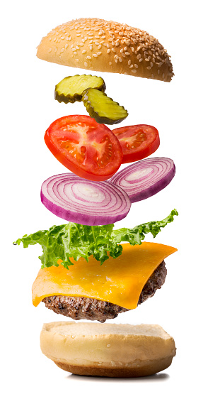 A cheeseburger being dropped into place.  The cheeseburger exploded view contains lettuce, red onion, tomato, and pickle with the bun top falling into place.  The photograph is on pure white for easy compositing.  Please see my portfolio for other food images. 