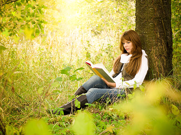 istock Girl reading a book in park 492853812
