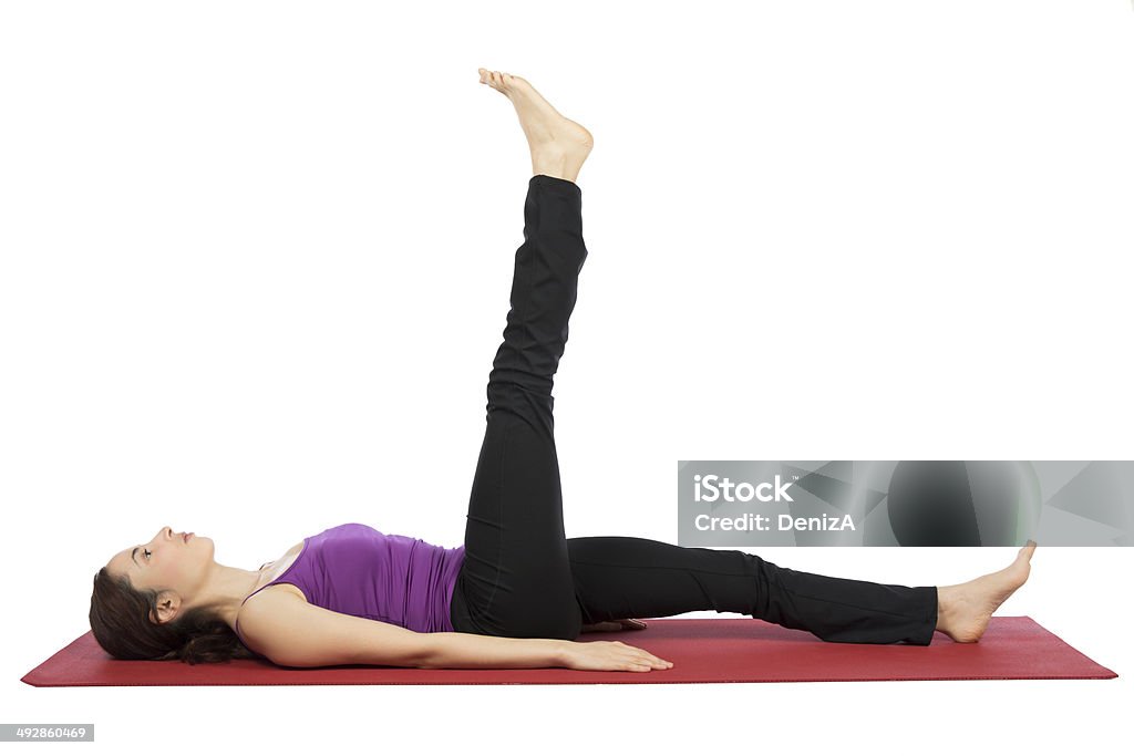 Woman doing leg raising exercises Young woman is doing leg raising exercises. 30-34 Years Stock Photo