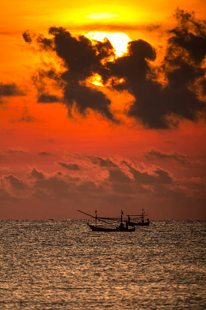istock Fisherman on the boat over dramatic sunrise 492864267