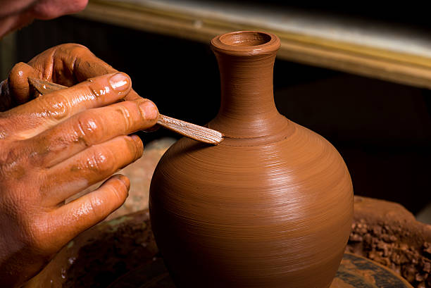istock hands of a potter, creating an earthen jar 492864599