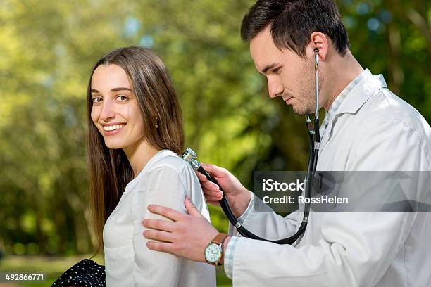 Young Doctor Listnening With Stethoscope In The Park Stock Photo - Download Image Now