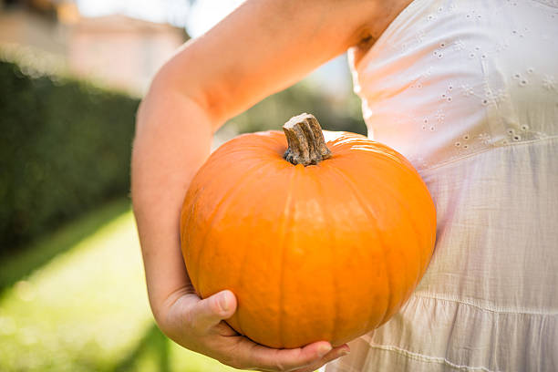 istock woman holding an halloween pumpkin 492880588