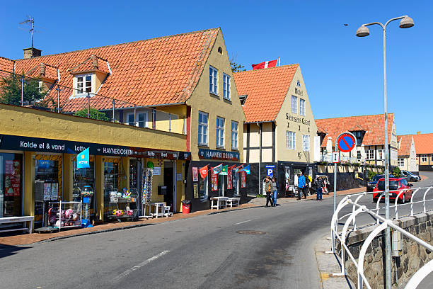 Svaneke, Denmark - August 14, 2015: Tourists enjoy the sunny weather and walk on the promenade along the harbor.