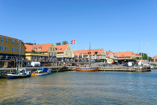 Svaneke, Denmark - August 14, 2015: Tourists enjoy the sunny weather and walking along the quay at the port.