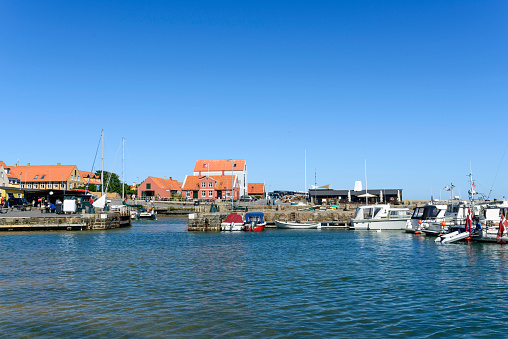 Svaneke, Denmark - August 14, 2015: Tourists enjoy the sunny weather and walking along the quay at the port.