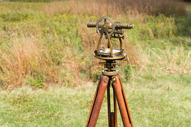 vintage inspetor de nível (trânsito, teodolito) com tripé em um campo. - levelling instrument imagens e fotografias de stock