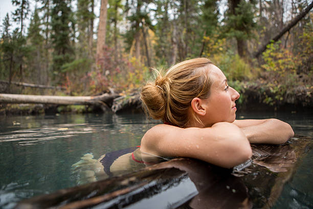 jovem mulher desfrutar de um banho natural, hot springs. - wood tranquil scene serene people lake imagens e fotografias de stock