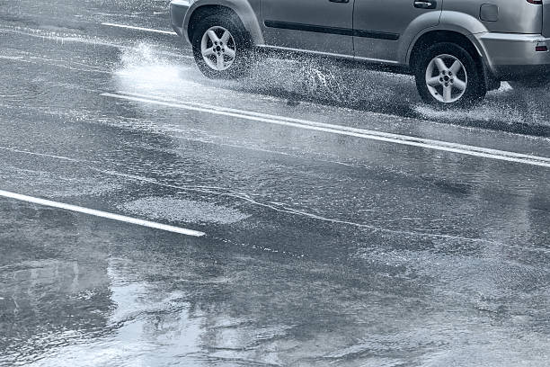 istock car rides on water splashing on the road 492890632