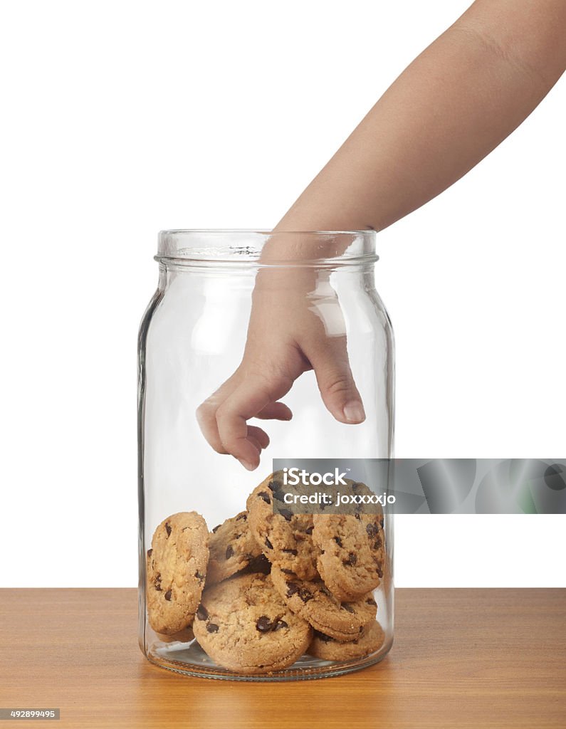 Stealing cookies Child's hand reaching out to take cookies from a jar Cookie Jar Stock Photo