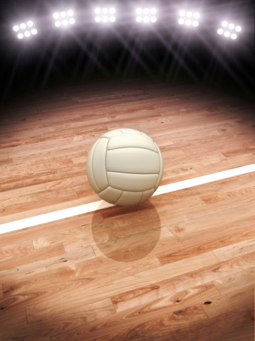 Volleyball on a court with stadium lighting with room for text or copy space