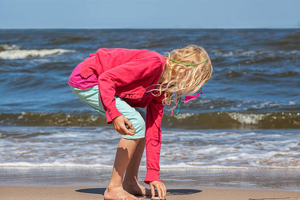 istock Girl collecting seashells 492902323