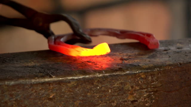 blacksmith forges a horseshoe, slow motion