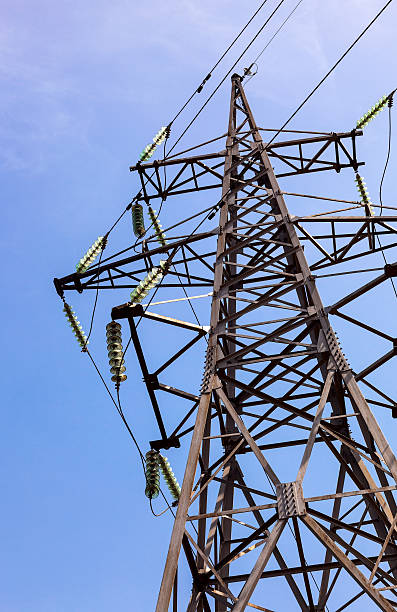 alta tensión eléctrica de torre contra el cielo azul - nonconductor fotografías e imágenes de stock