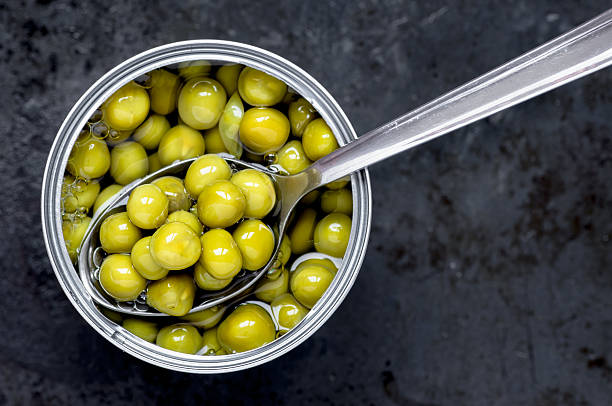 istock Canned green peas tin can with a spoon 492904980
