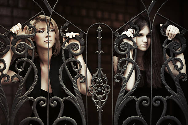 istock Two sad young women at the cast iron fence 492905353